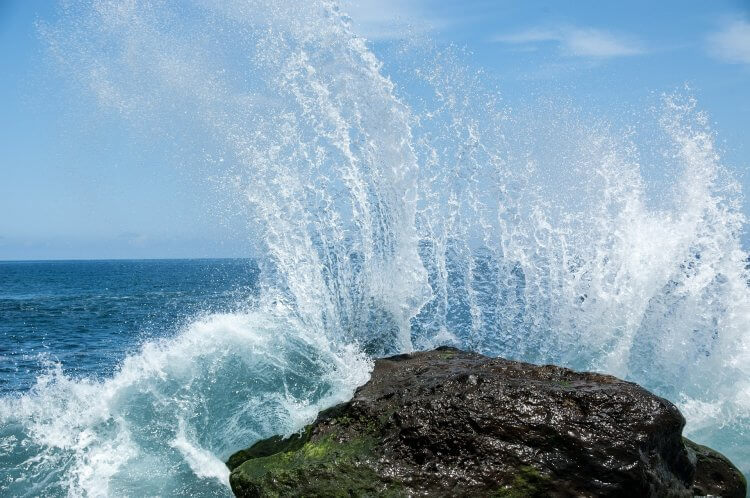 Wave crashing on a large rock