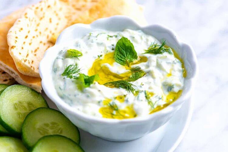 Tzatziki dip with dill, pita and cucumbers.