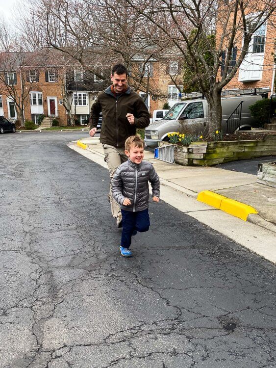 Father and Son having a race down the road near the house.