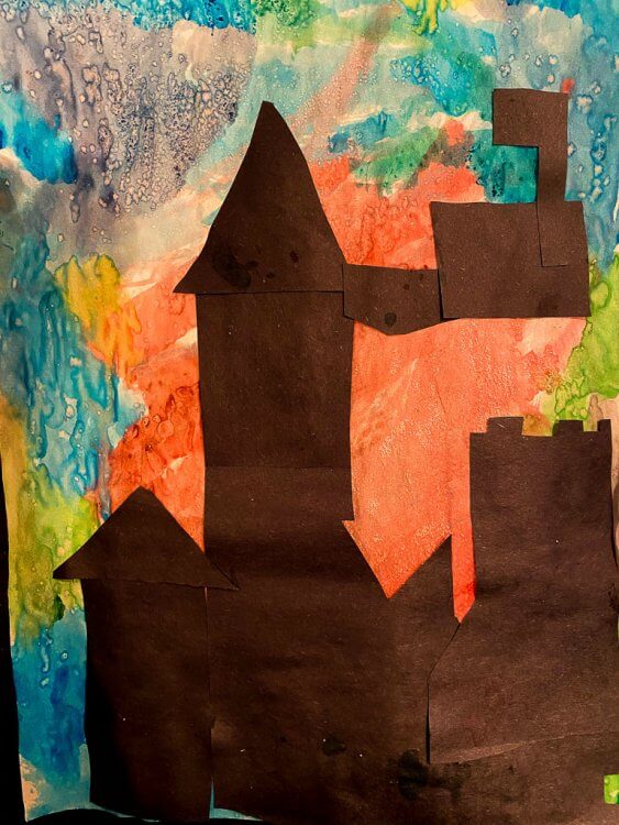 Watercolor painting with silhouette of a castle.
