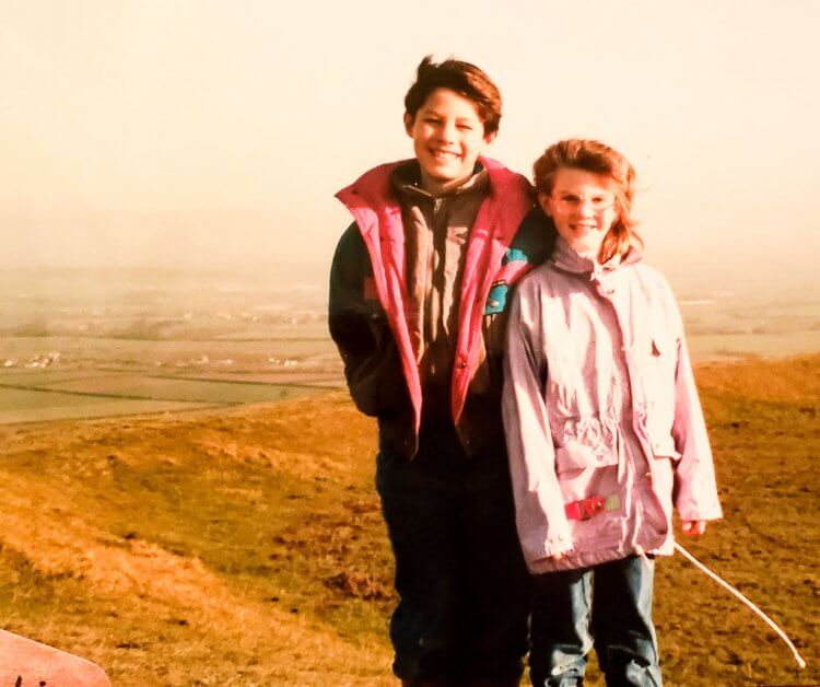 Vintage photo of a boy and a little girl standing together in England.
