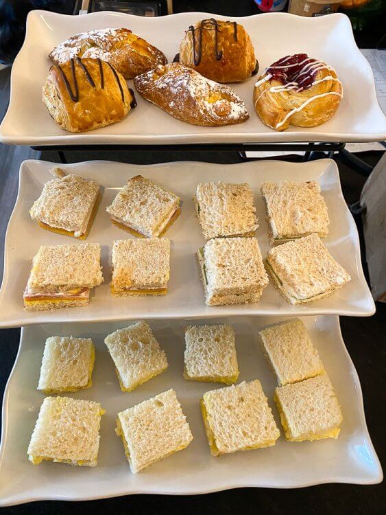 Three tiered platter with tea sandwiches and pastries.