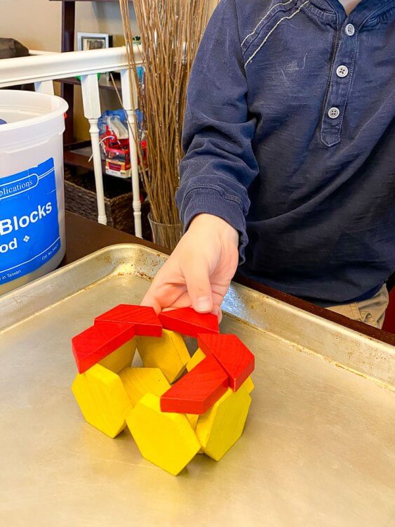 Building a tower with blocks on a cookie sheet.