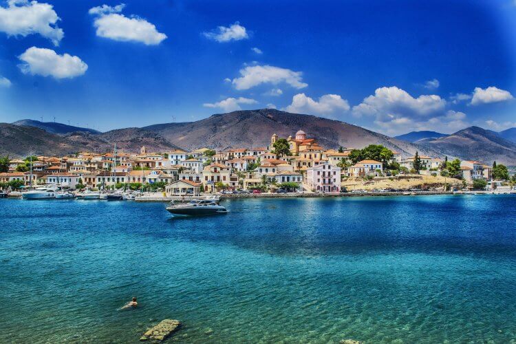 Turquoise waters looking towards a city on the water.